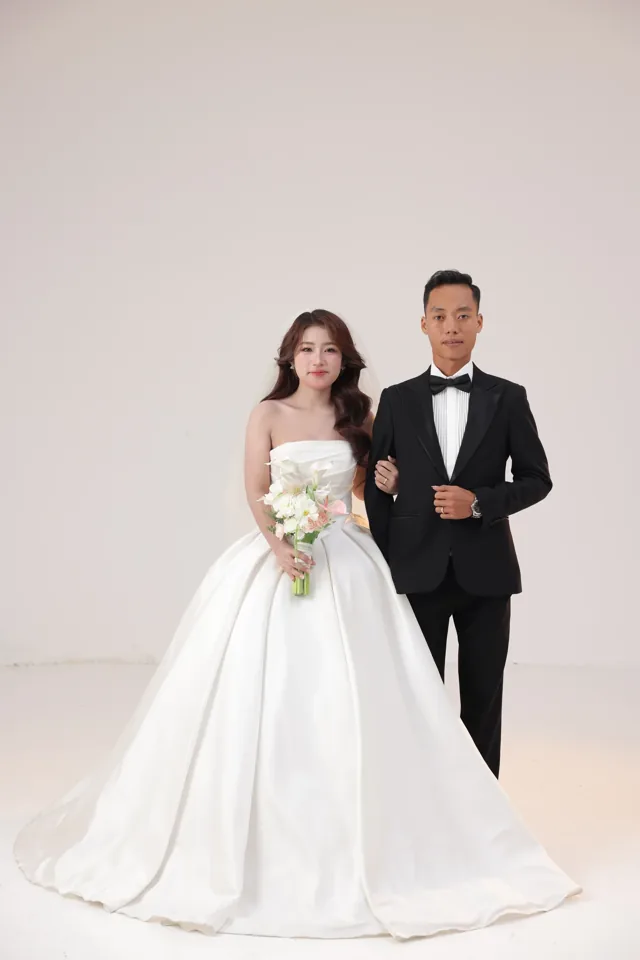 Khoa và Phương trong trang phục cưới bên phông sáng