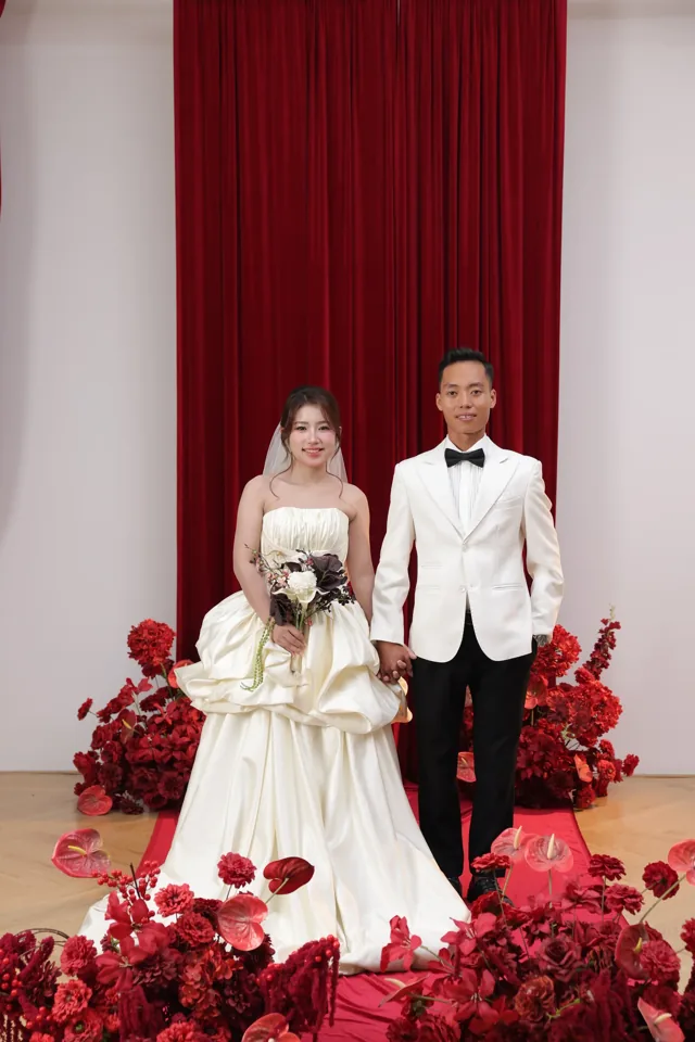 Khoa và Phương đứng giữa những khóm hoa đỏ