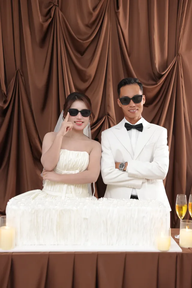 Khoa và Phương đeo kính râm bên bàn bánh và ly